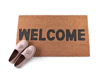 Stylish door mat with word Welcome and female shoes on white background, top view