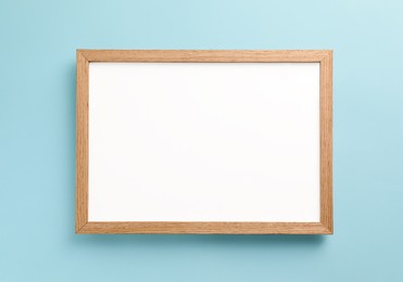 Photo of Blank white board on turquoise background, top view. Space for text