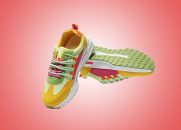 Image of Pair of stylish sneakers in air on red background
