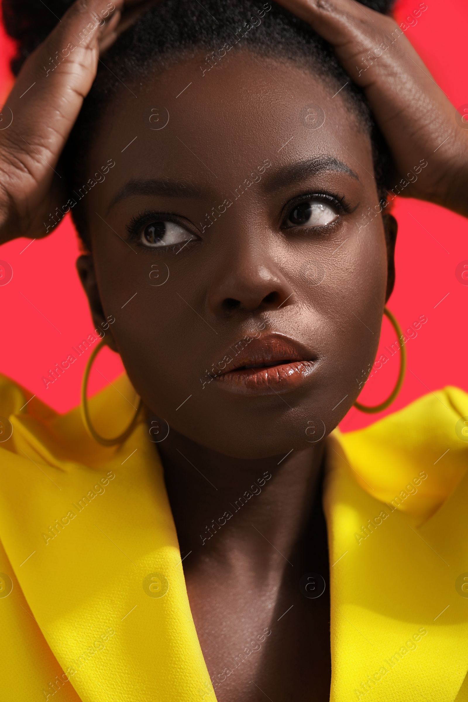 Photo of Fashionable portrait of beautiful woman on coral background, closeup