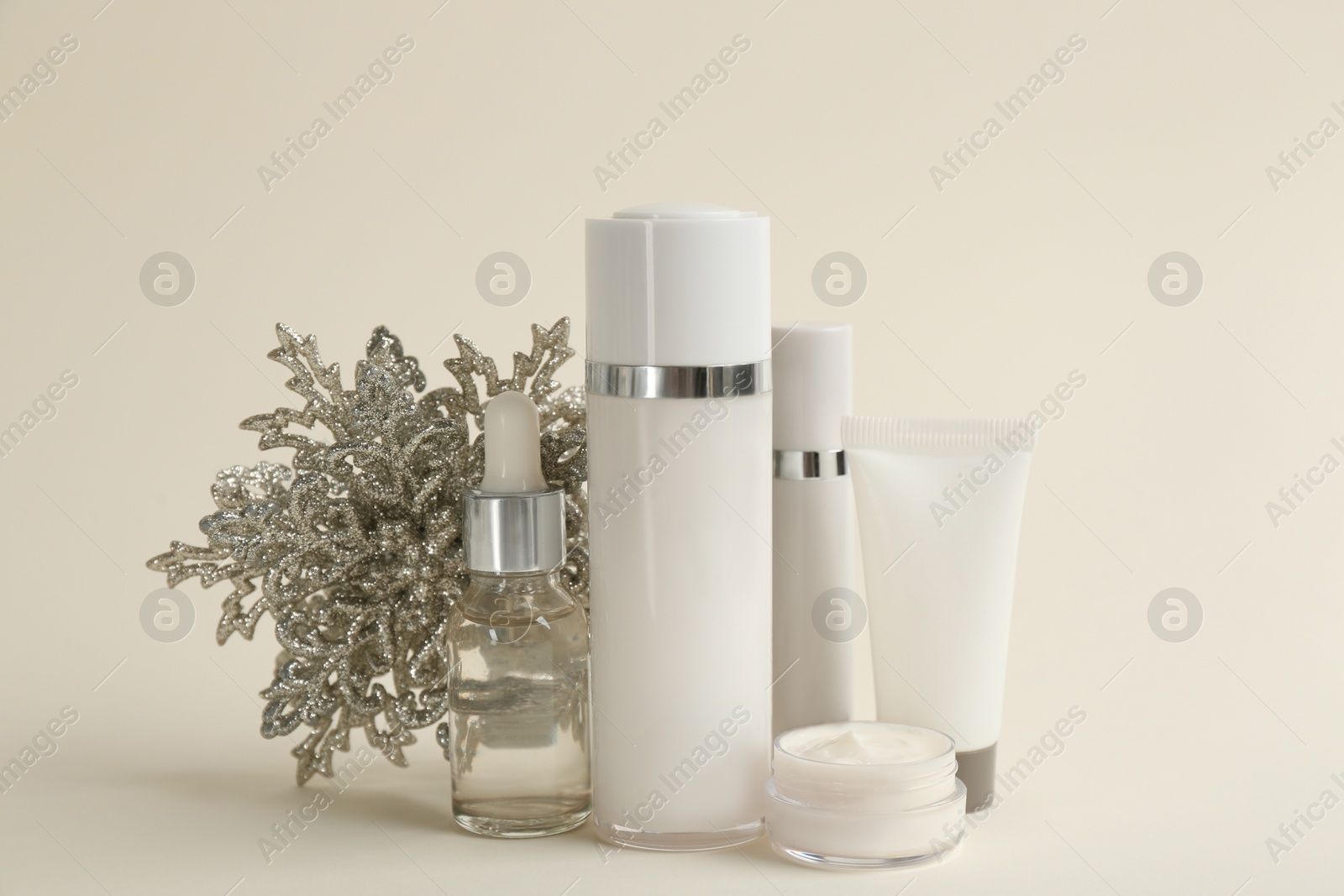 Photo of Beautiful composition with cosmetic products on beige background. Winter care