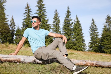 Photo of Handsome man enjoying beautiful landscape on sunny day