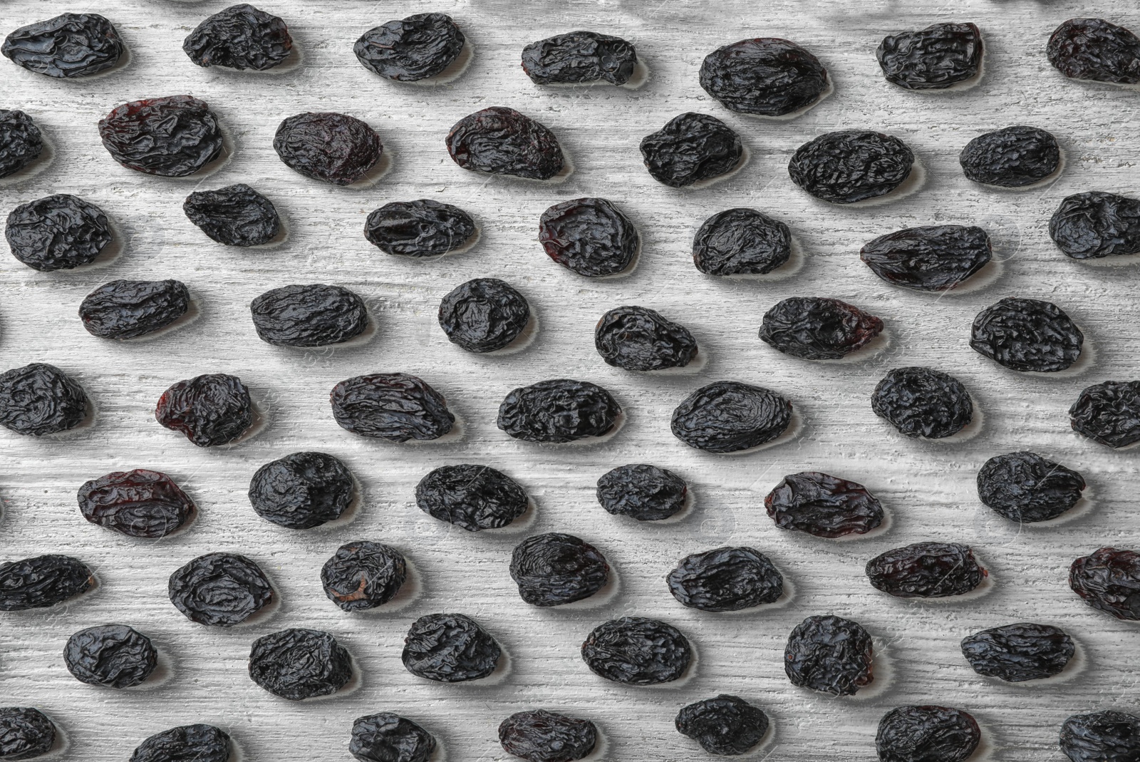 Photo of Flat lay composition with raisins on white wooden background. Dried fruit as healthy snack