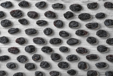 Photo of Flat lay composition with raisins on white wooden background. Dried fruit as healthy snack