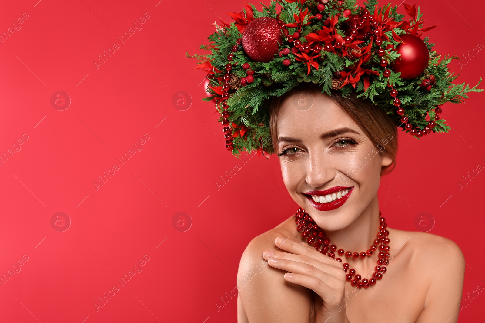 Photo of Beautiful young woman wearing Christmas wreath on red background. Space for text