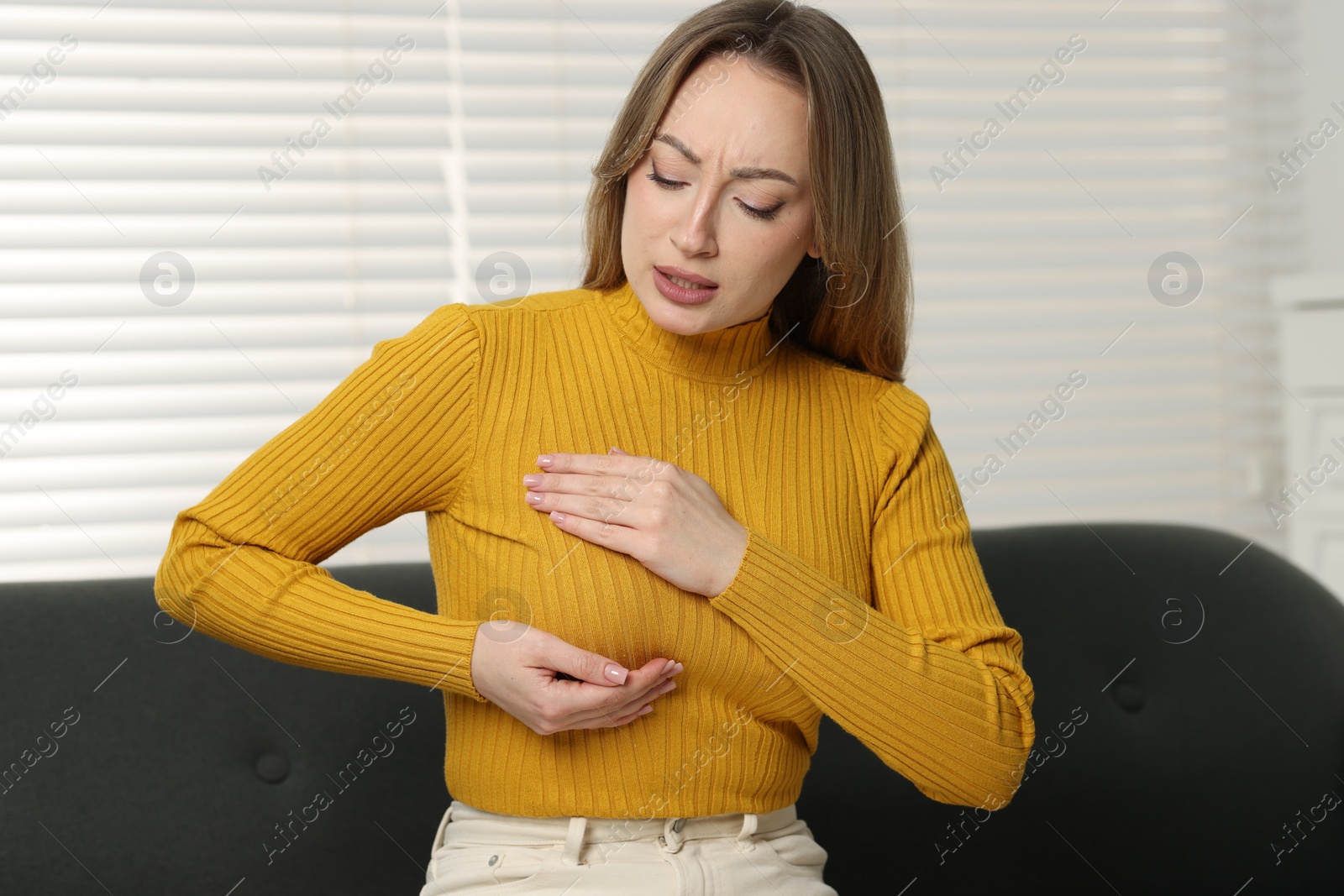 Photo of Mammology. Young woman doing breast self-examination at home