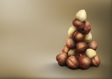 Image of Many hazelnuts on light brown gradient background, space for text