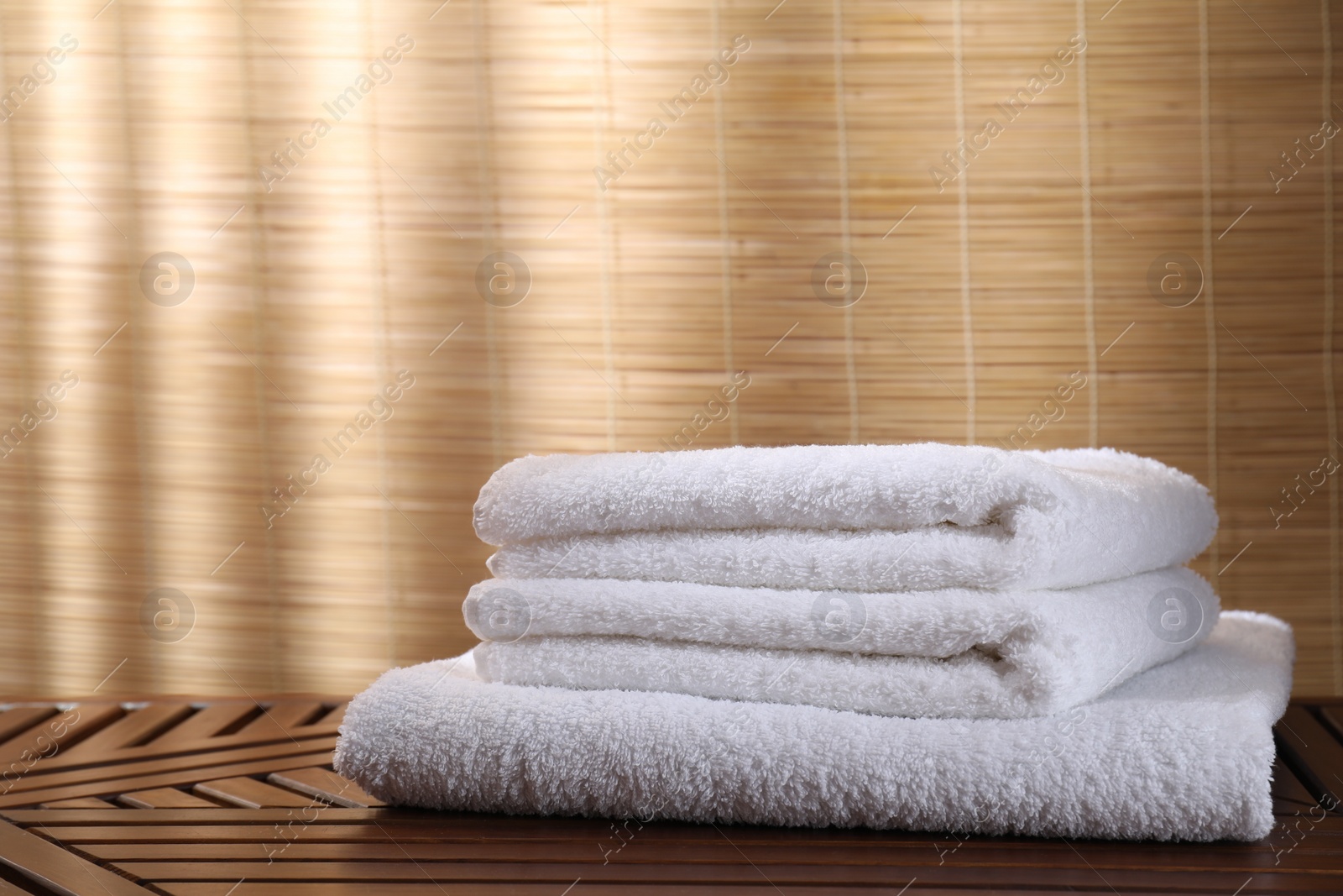 Photo of Stacked soft towels on wooden table indoors