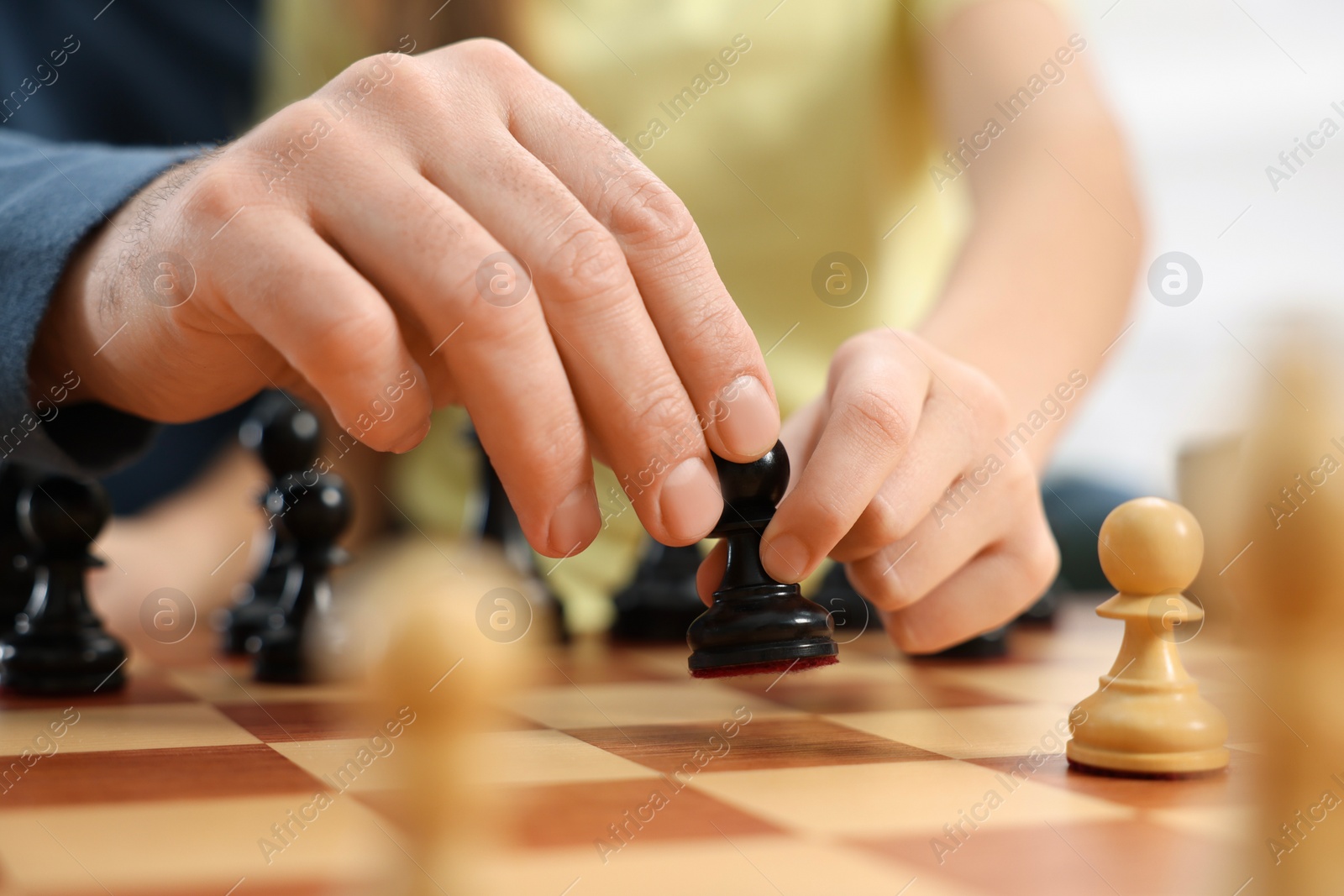 Photo of Father teaching his daughter to play chess, closeup