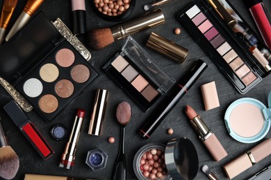 Photo of Flat lay composition with makeup products on black slate table