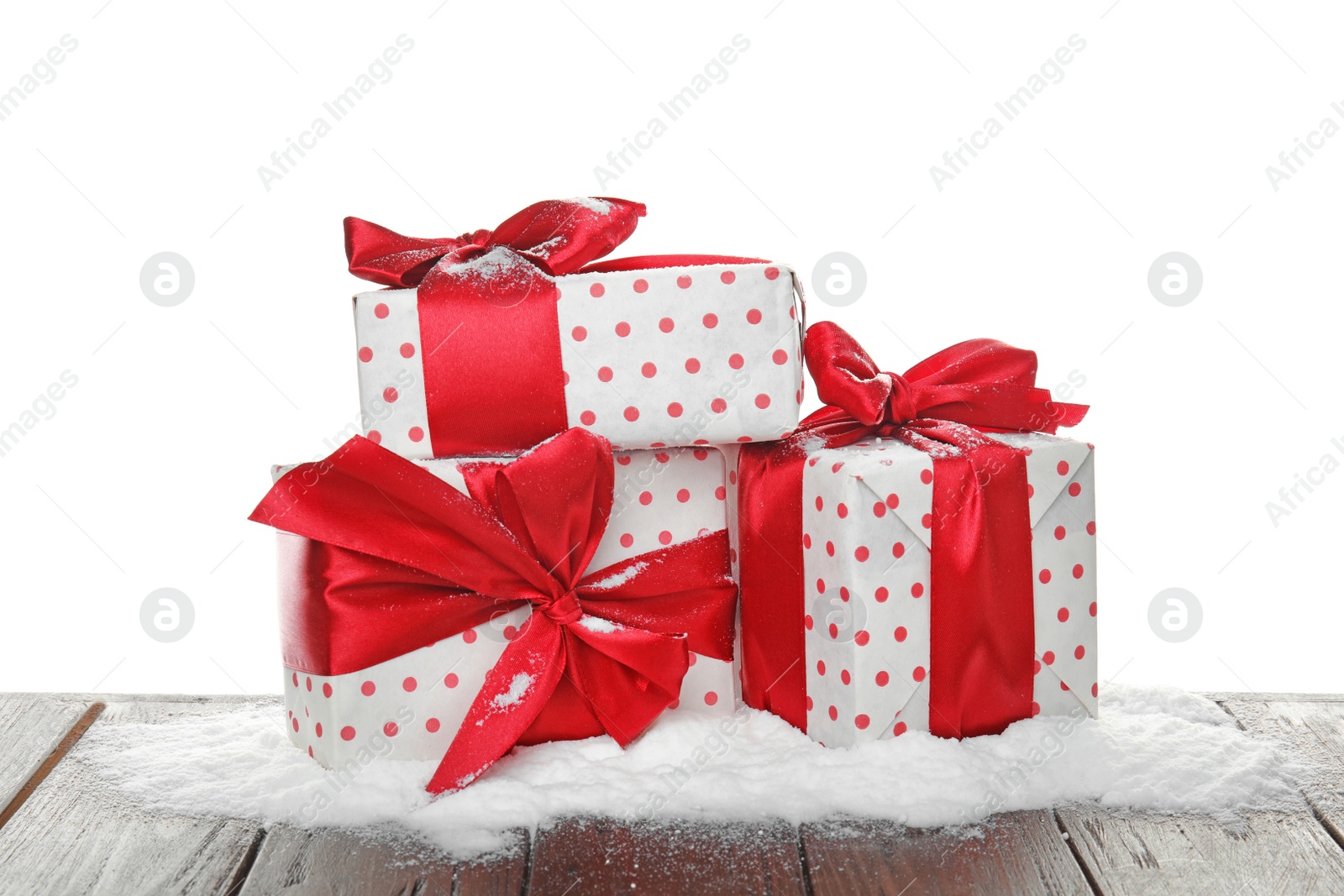 Photo of Christmas gift boxes and snow on table against white background