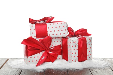 Photo of Christmas gift boxes and snow on table against white background