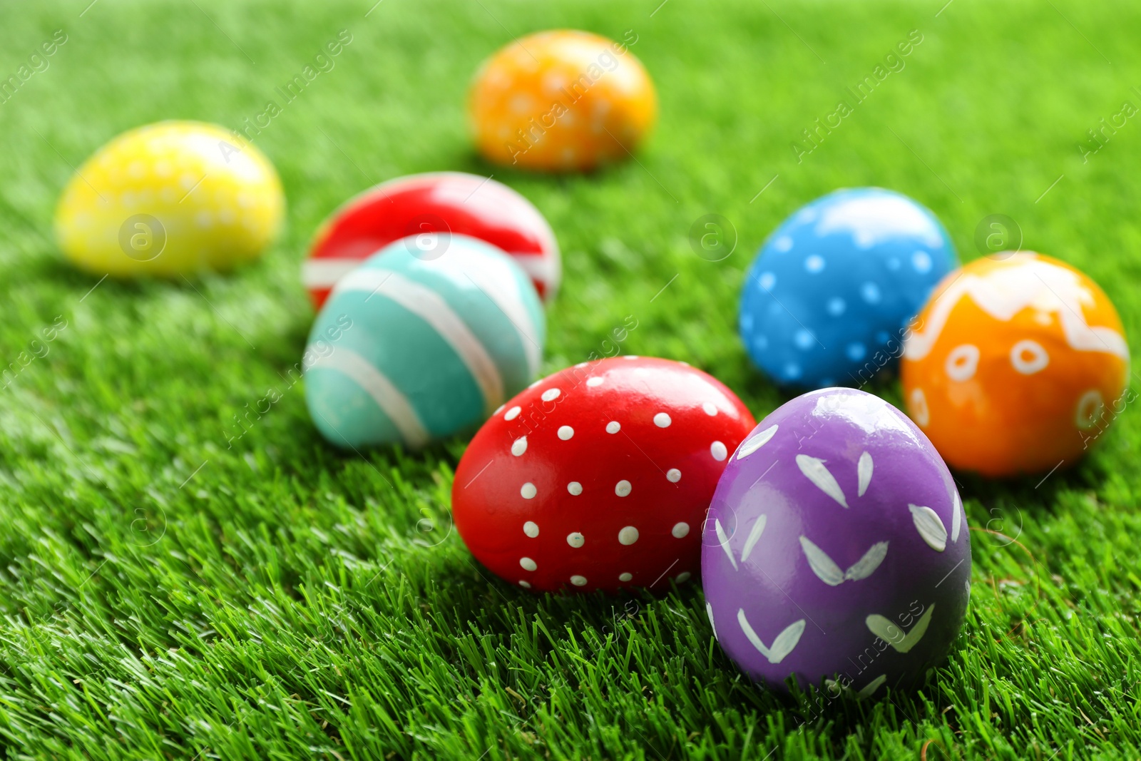 Photo of Colorful painted Easter eggs on green grass, space for text