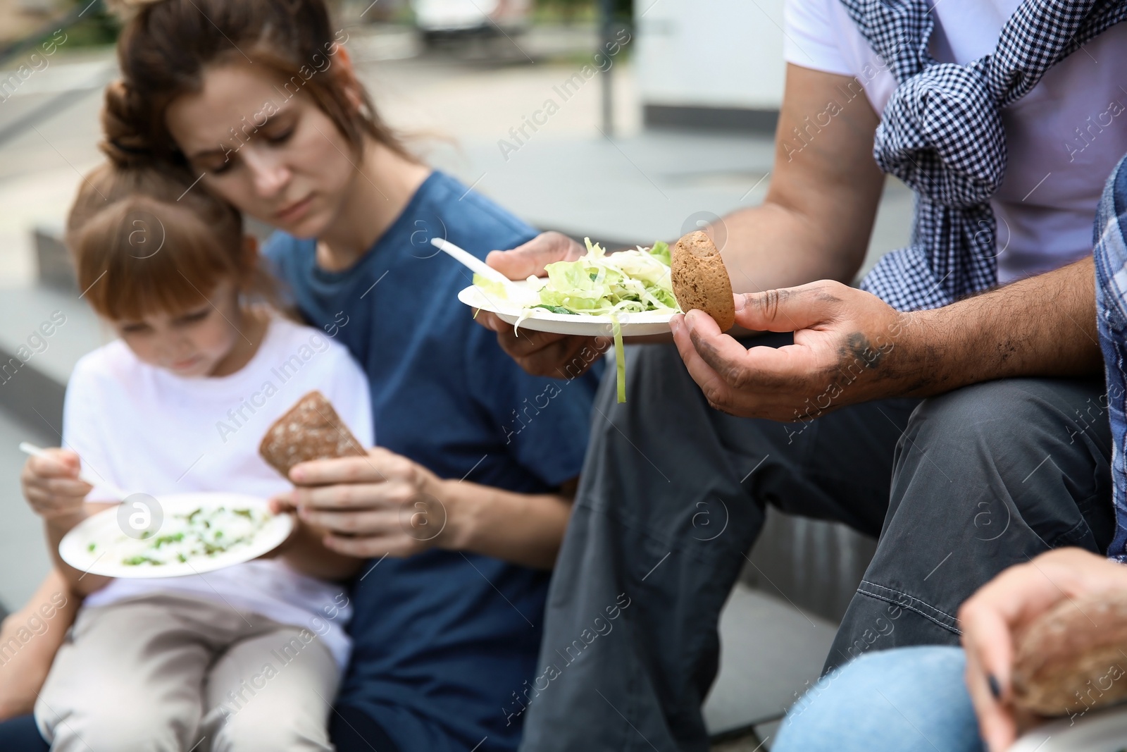 Photo of Poor people eating donated food on street