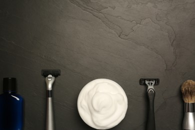 Set of men's shaving tools on black textured table, flat lay. Space for text