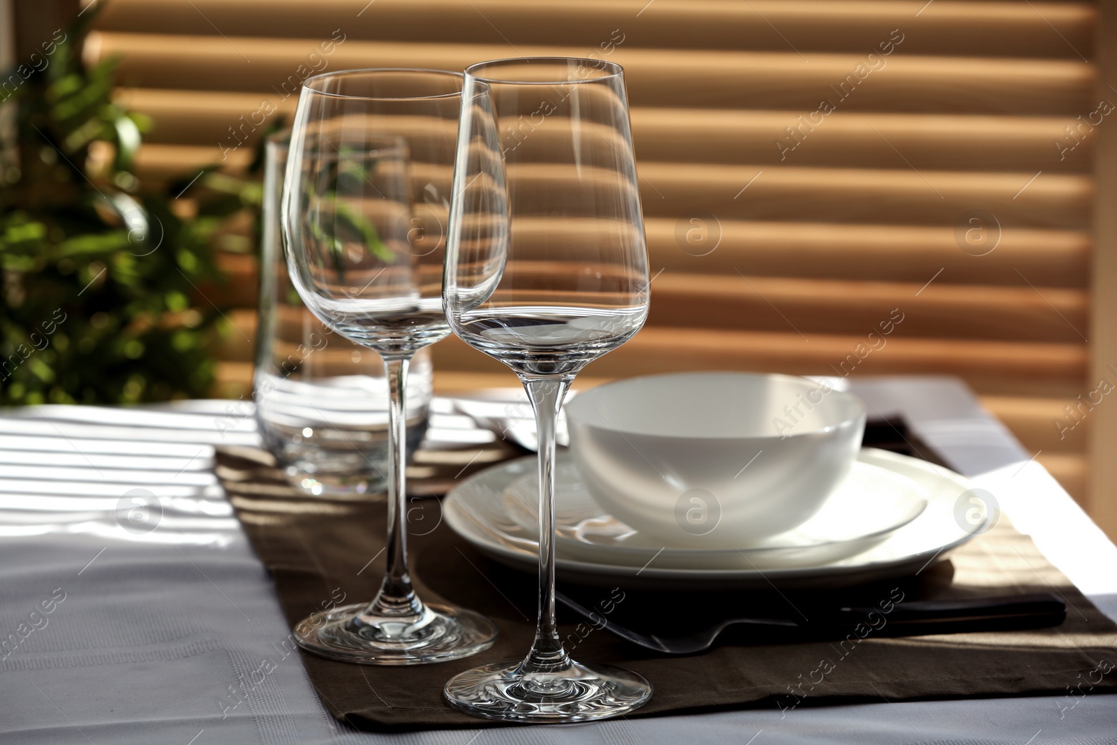 Photo of Table setting with empty wine glasses and dishware