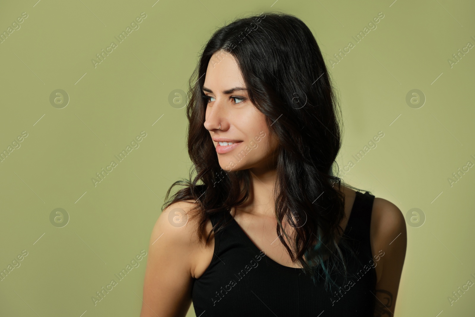 Photo of Beautiful young woman with nose piercing on green background