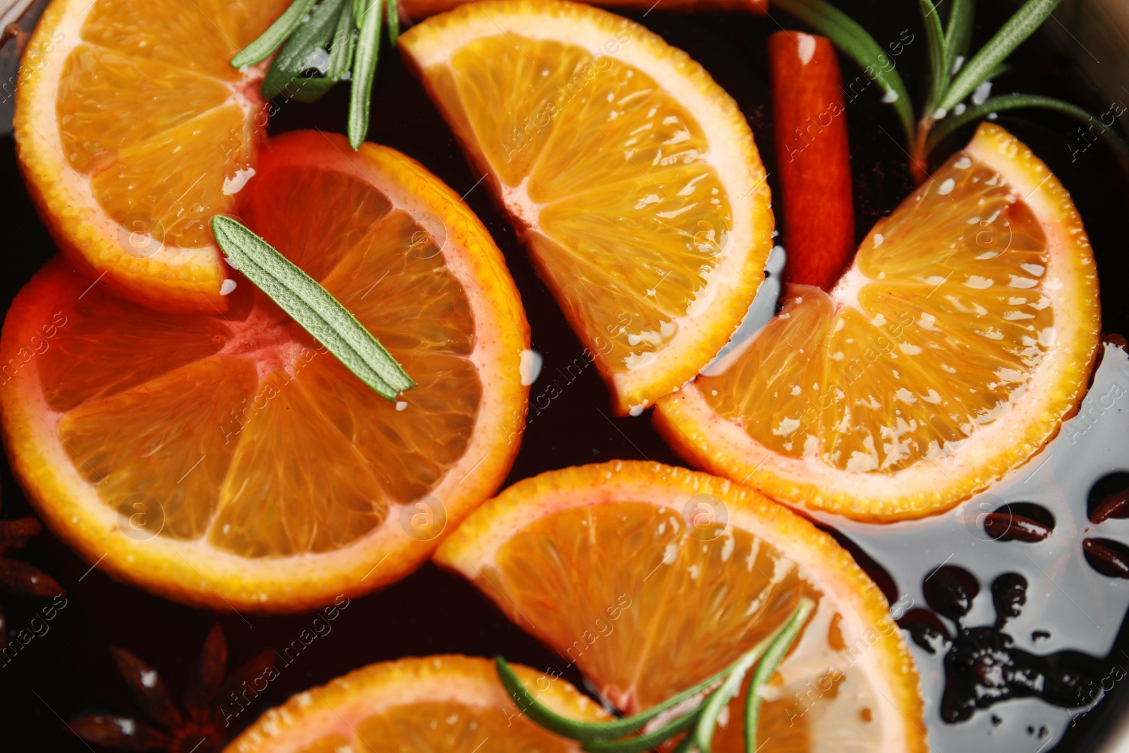 Photo of Tasty mulled wine with spices as background, closeup