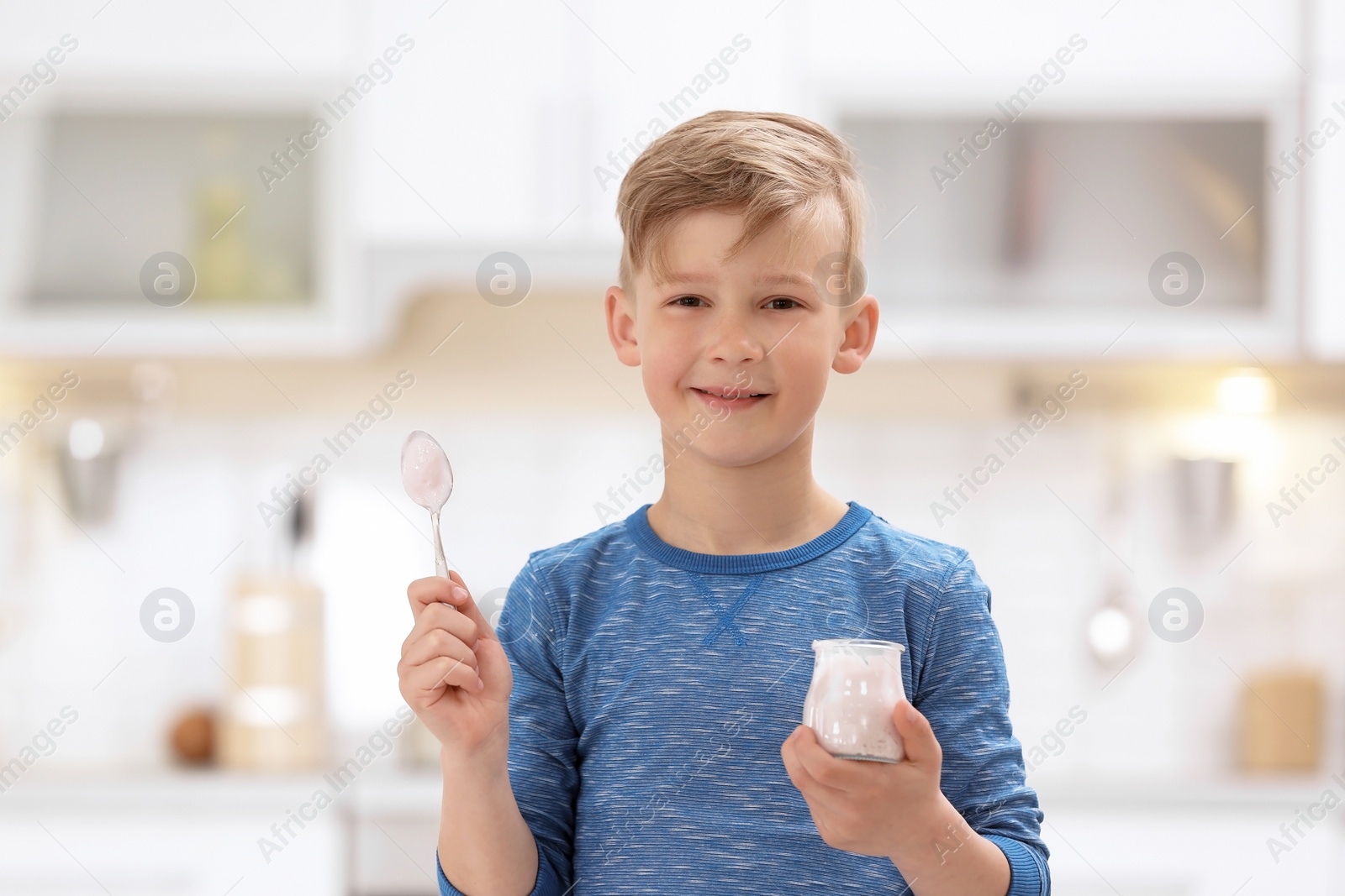 Photo of Little boy with yogurt on blurred background