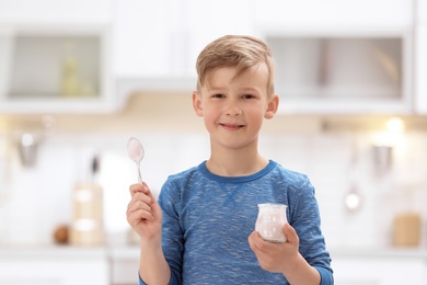 Little boy with yogurt on blurred background