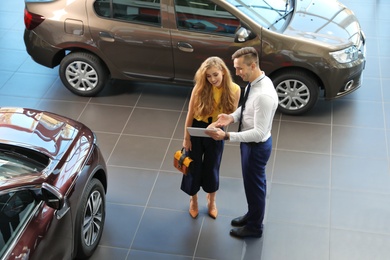 Young car salesman working with client in dealership