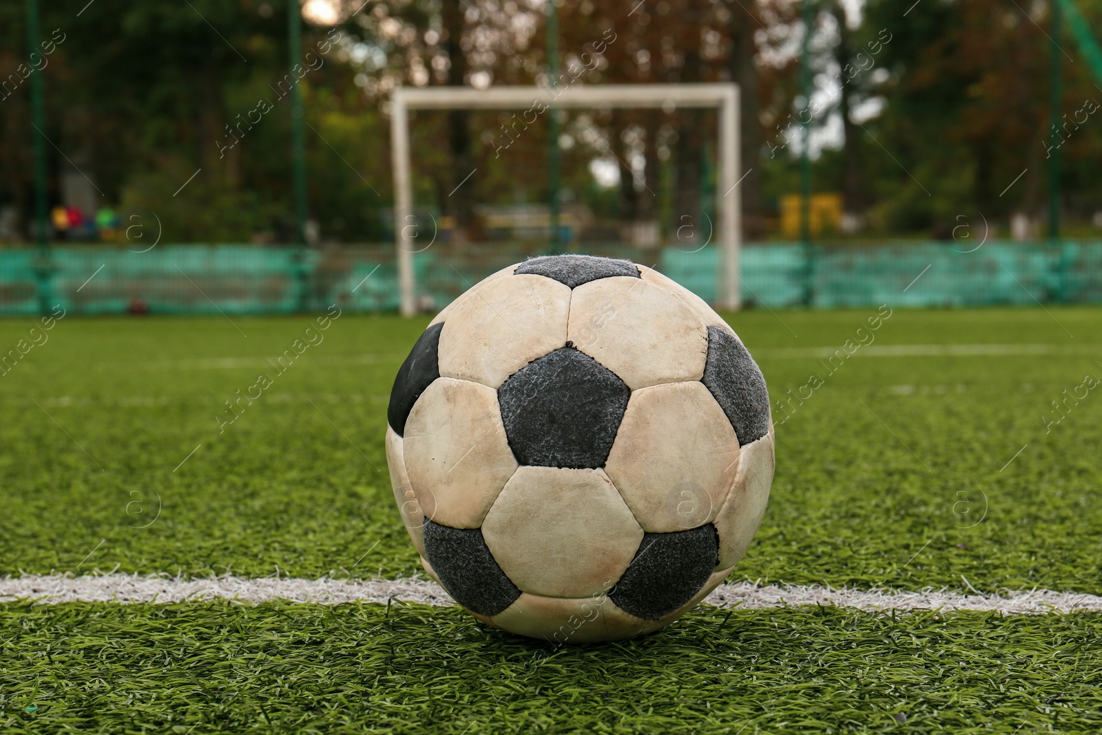 Photo of Dirty soccer ball on green football field