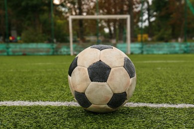 Photo of Dirty soccer ball on green football field