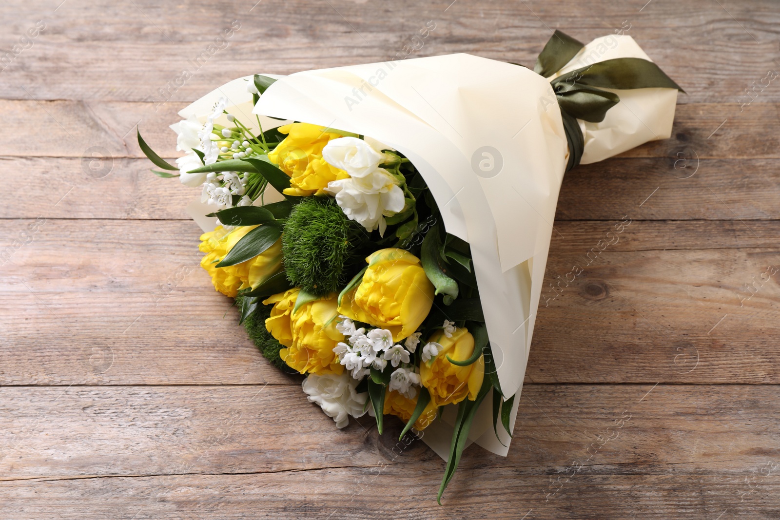 Photo of Beautiful bouquet with peony tulips on wooden table