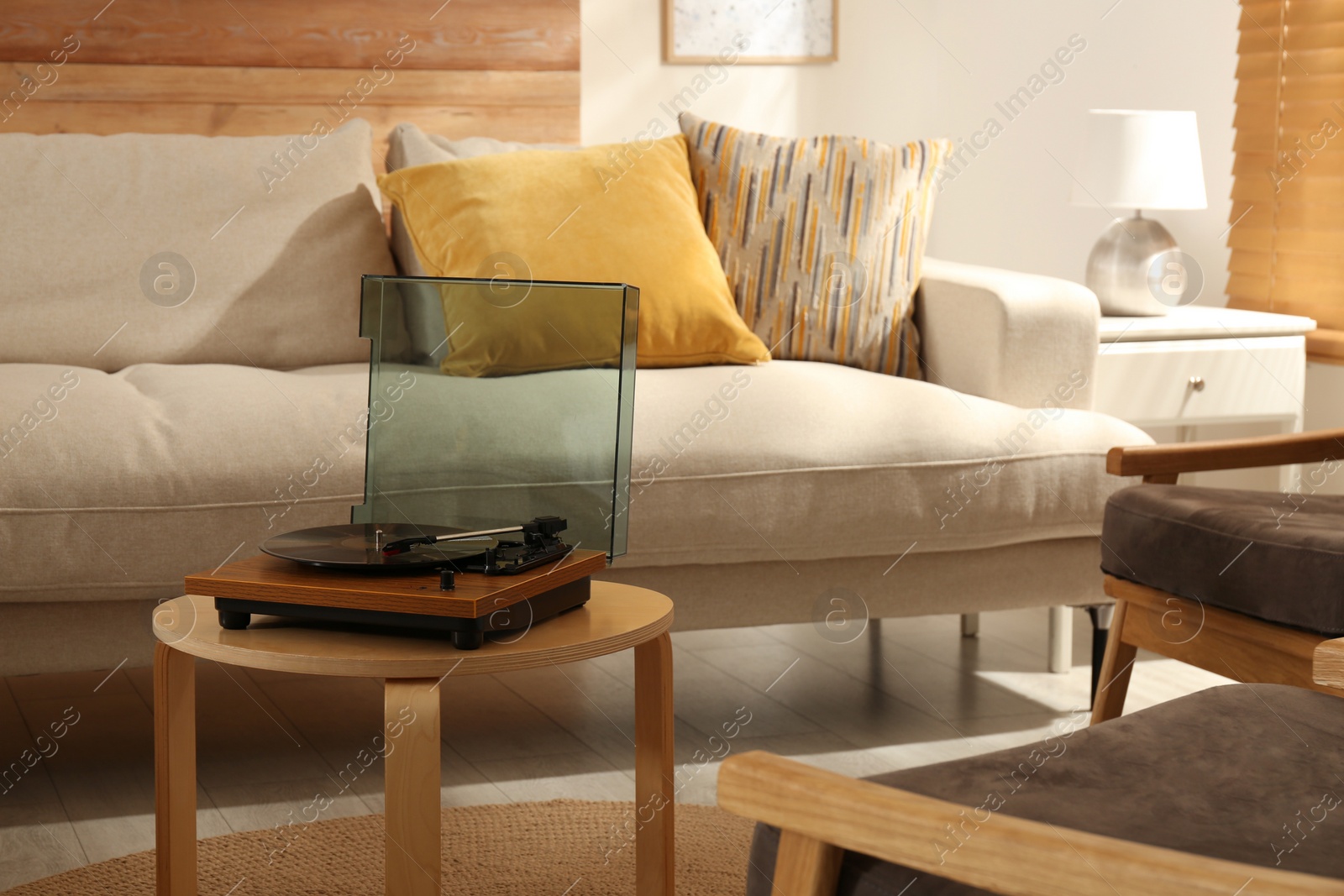 Photo of Modern vinyl record player with disc on table indoors