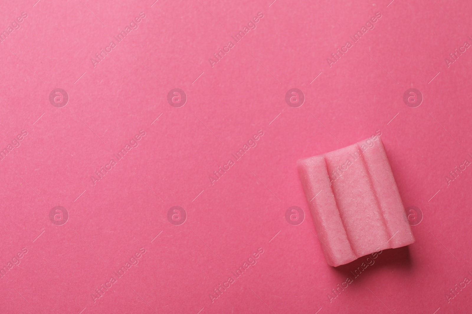 Photo of Tasty chewing gum on pink background, top view. Space for text