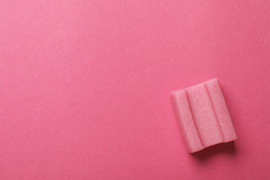 Photo of Tasty chewing gum on pink background, top view. Space for text