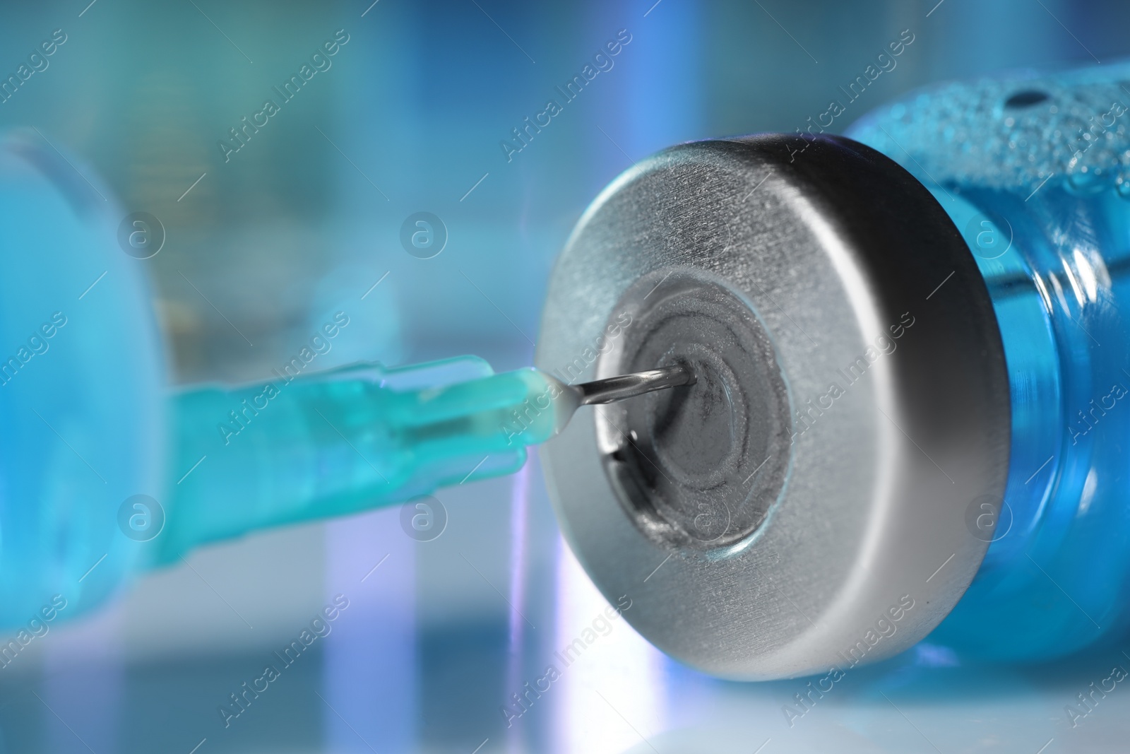 Photo of Filling syringe with medicine from vial on table, closeup