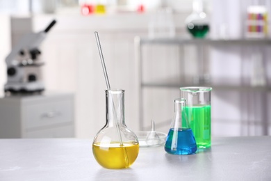 Photo of Laboratory glassware with samples on table indoors, space for text. Solution chemistry