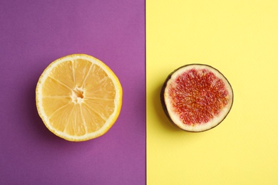 Photo of Lemon and cut fig on color background, flat lay