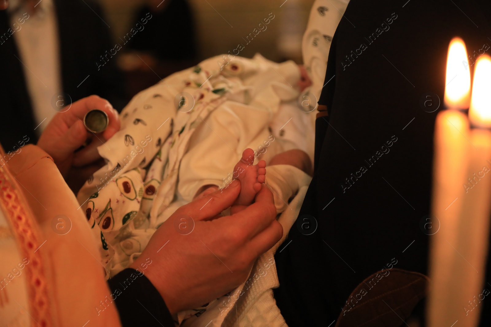 Photo of Stryi, Ukraine - September 11, 2022: Father holding child during baptism ceremony in Assumption of Blessed Virgin Mary cathedral, closeup