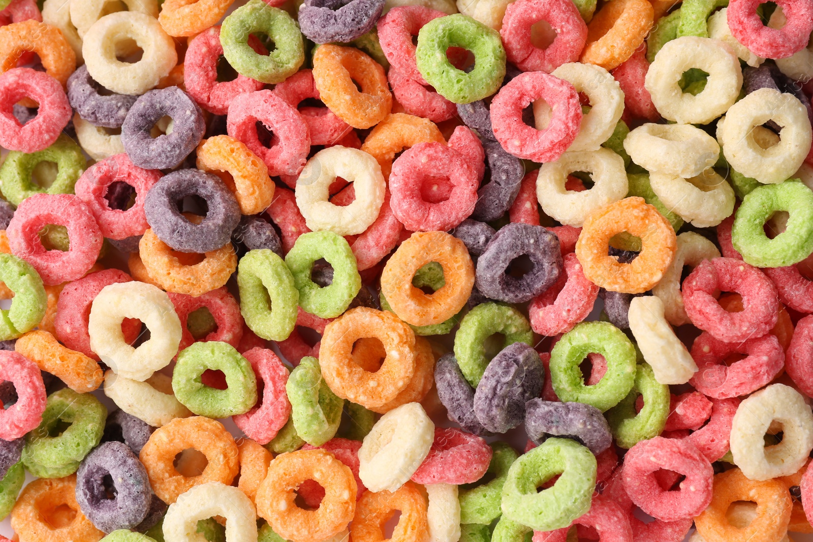 Photo of Sweet tasty colorful corn rings as background, top view