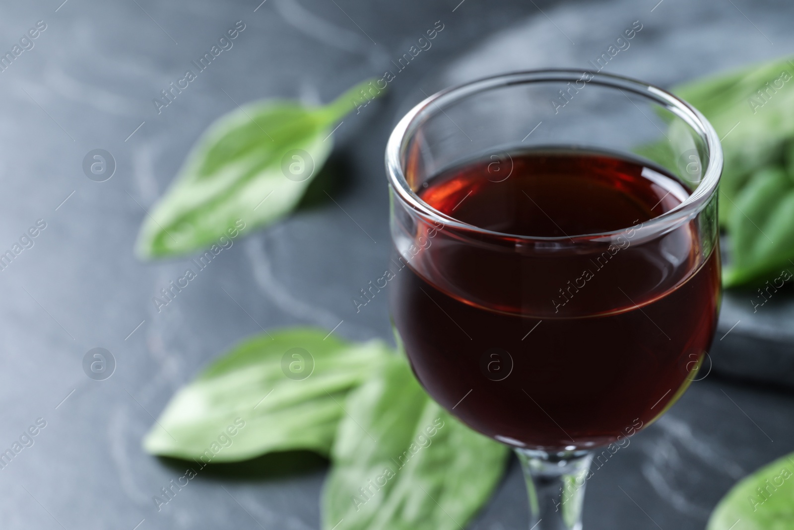 Photo of Glass of broadleaf plantain tincture, closeup. Space for text