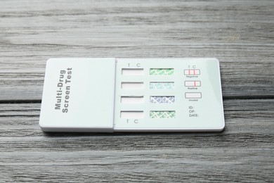Photo of Multi-drug screen test on grey wooden table, closeup