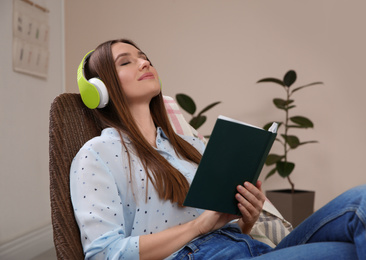 Woman listening to audiobook in chair at home