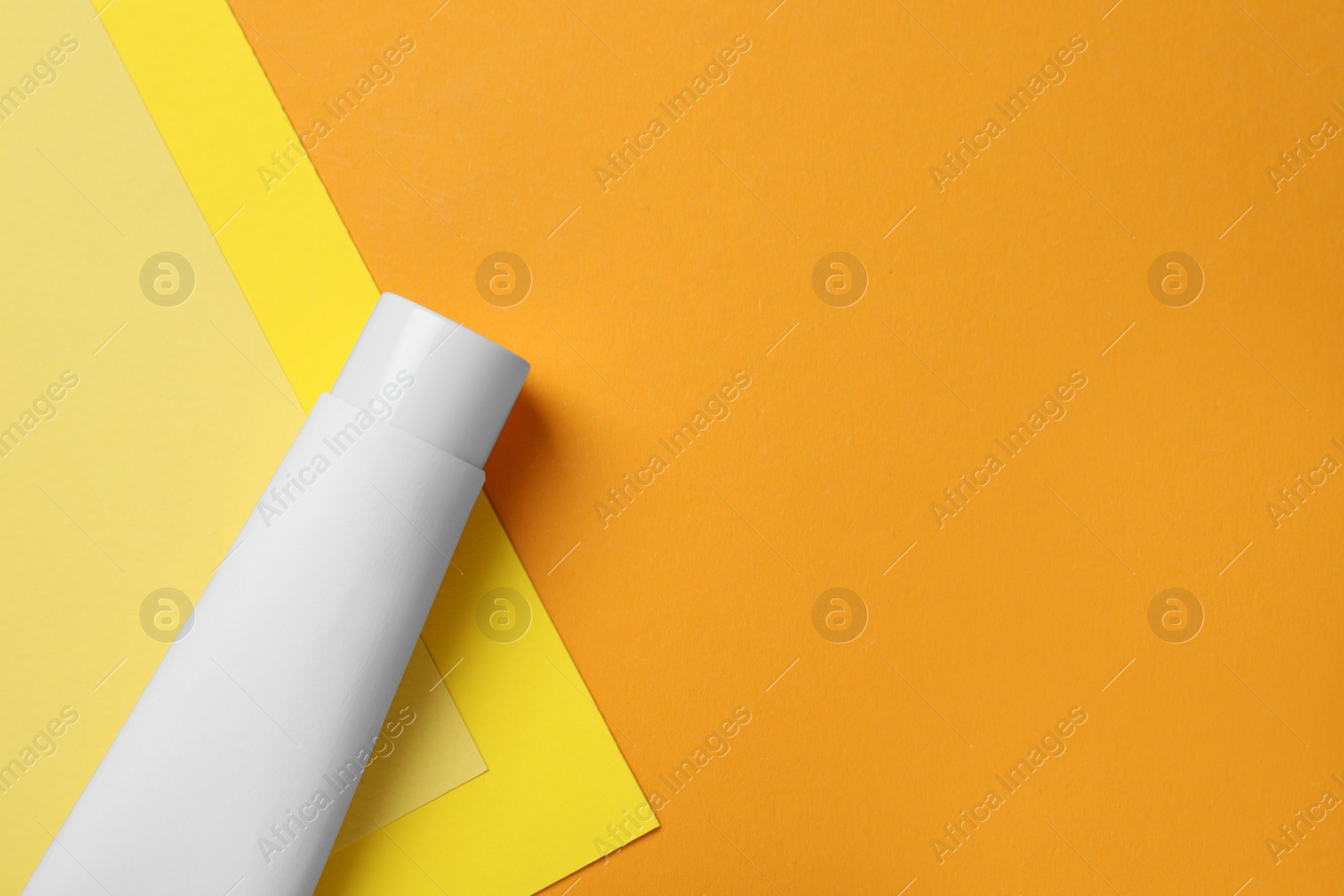 Photo of Blank tube of toothpaste on color background, top view. Space for text