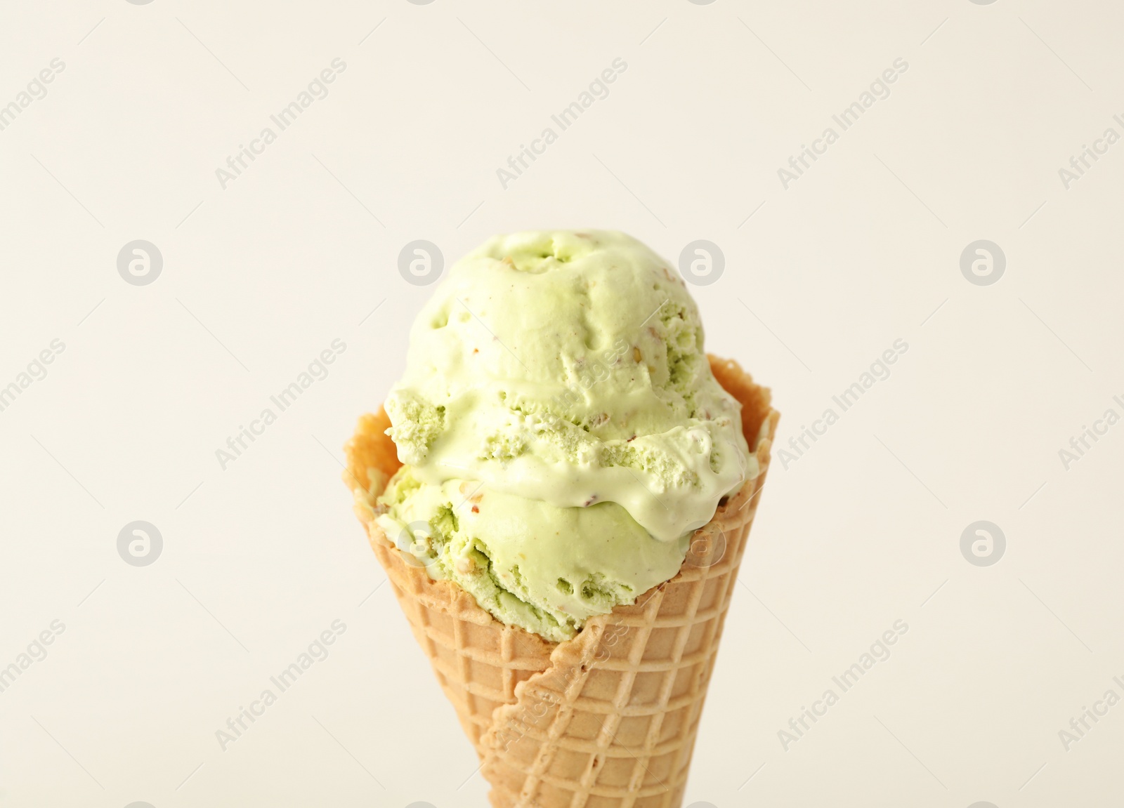 Photo of Delicious ice cream in waffle cone on white background, closeup