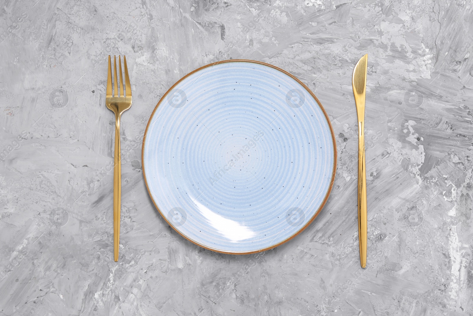 Photo of Elegant setting with shiny cutlery on grey table, top view