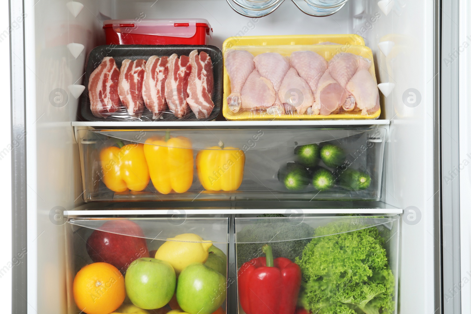 Photo of Open refrigerator with many different products, closeup