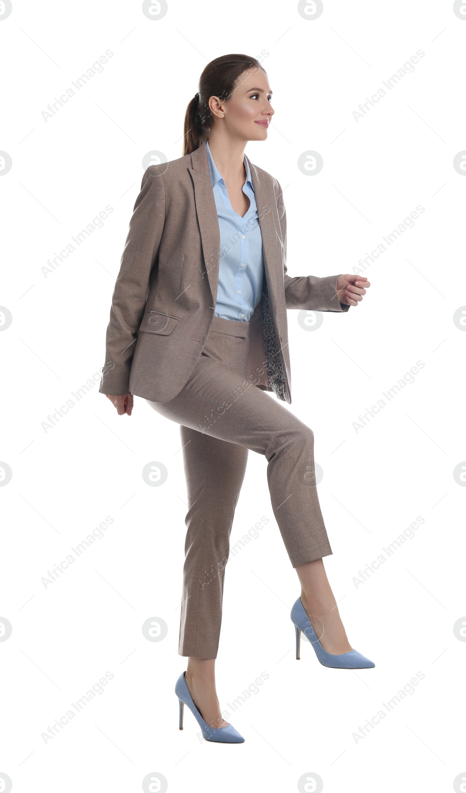 Photo of Businesswoman imitating stepping up on stairs against white background. Career ladder concept