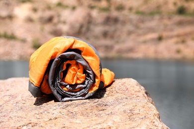 Photo of Rolled sleeping bag on sunny day outdoors. Space for text