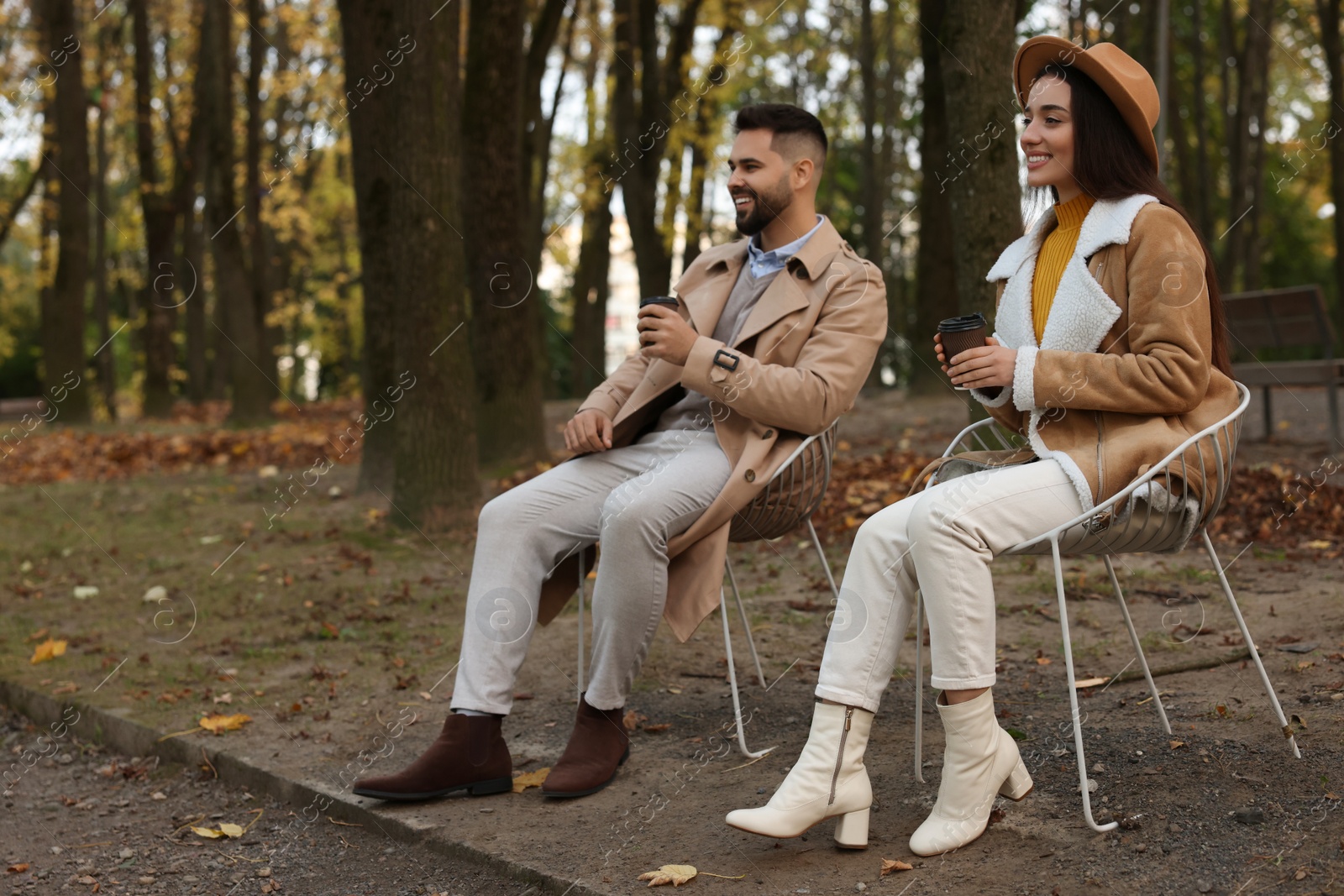 Photo of Romantic young couple spending time together in autumn park, space for text