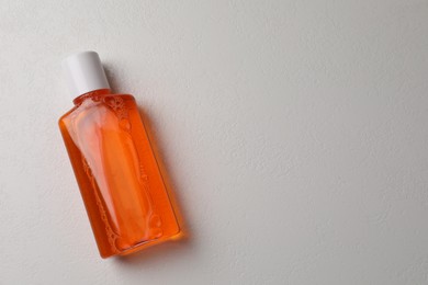 Photo of Fresh mouthwash in bottle on white background, top view. Space for text