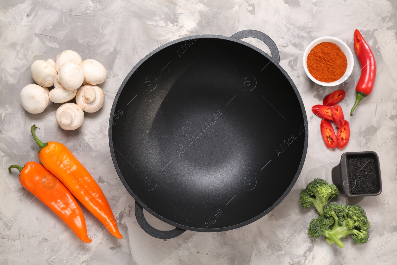 Photo of Wok and different products on grey textured table, flat lay