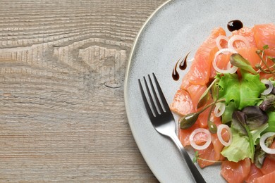 Photo of Delicious salmon carpaccio served on wooden table, top view. Space for text