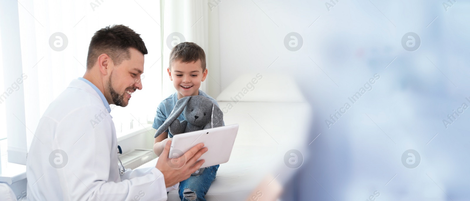 Image of Doctor working with little patient in clinic, space for text. Banner design